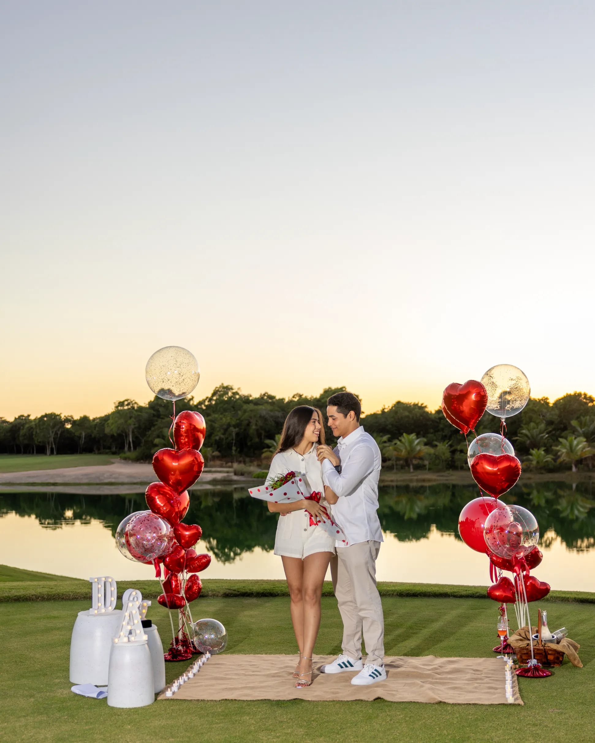 Montaje completo de propuesta de matrimonio con globos y velas junto a una laguna en Punta Cana
