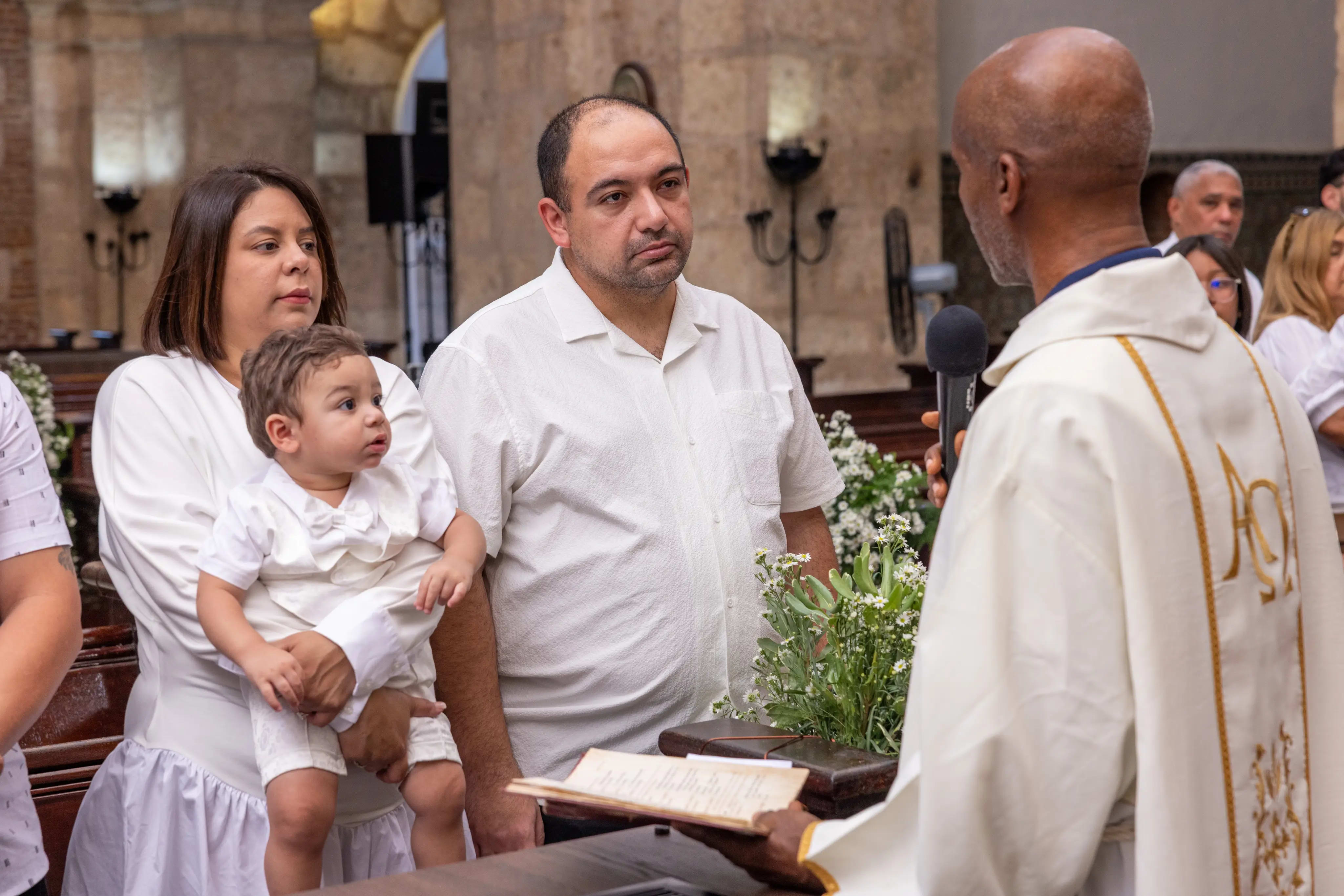Padrinos y sacerdote con bebé vestido de blanco junto al atril, interior de iglesia colonial de piedra, Santo Domingo — Babula Shots