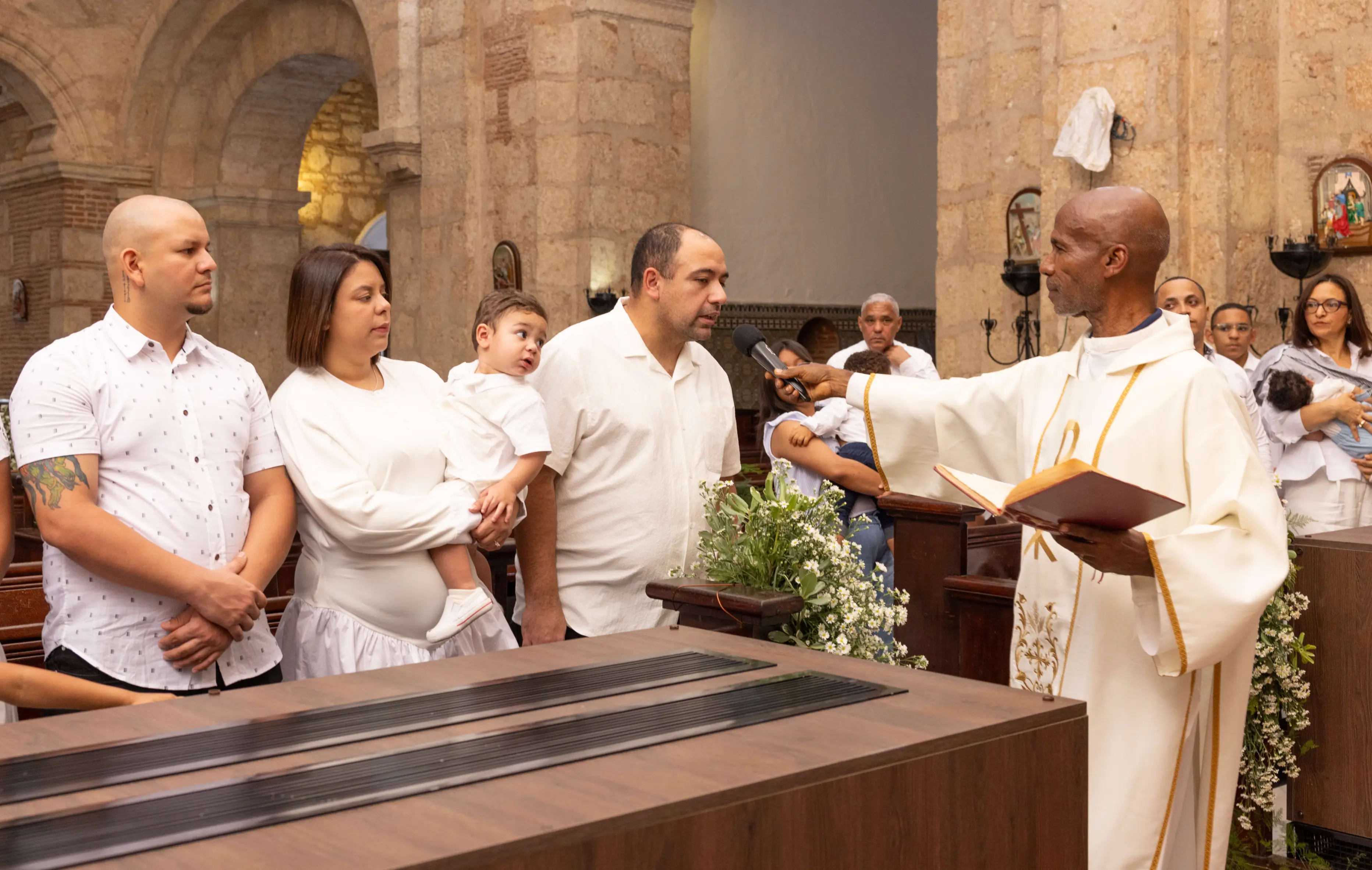Sacerdote leyendo el rito del bautizo junto a los vitrales de una iglesia de la Zona Colonial — Babula Shots