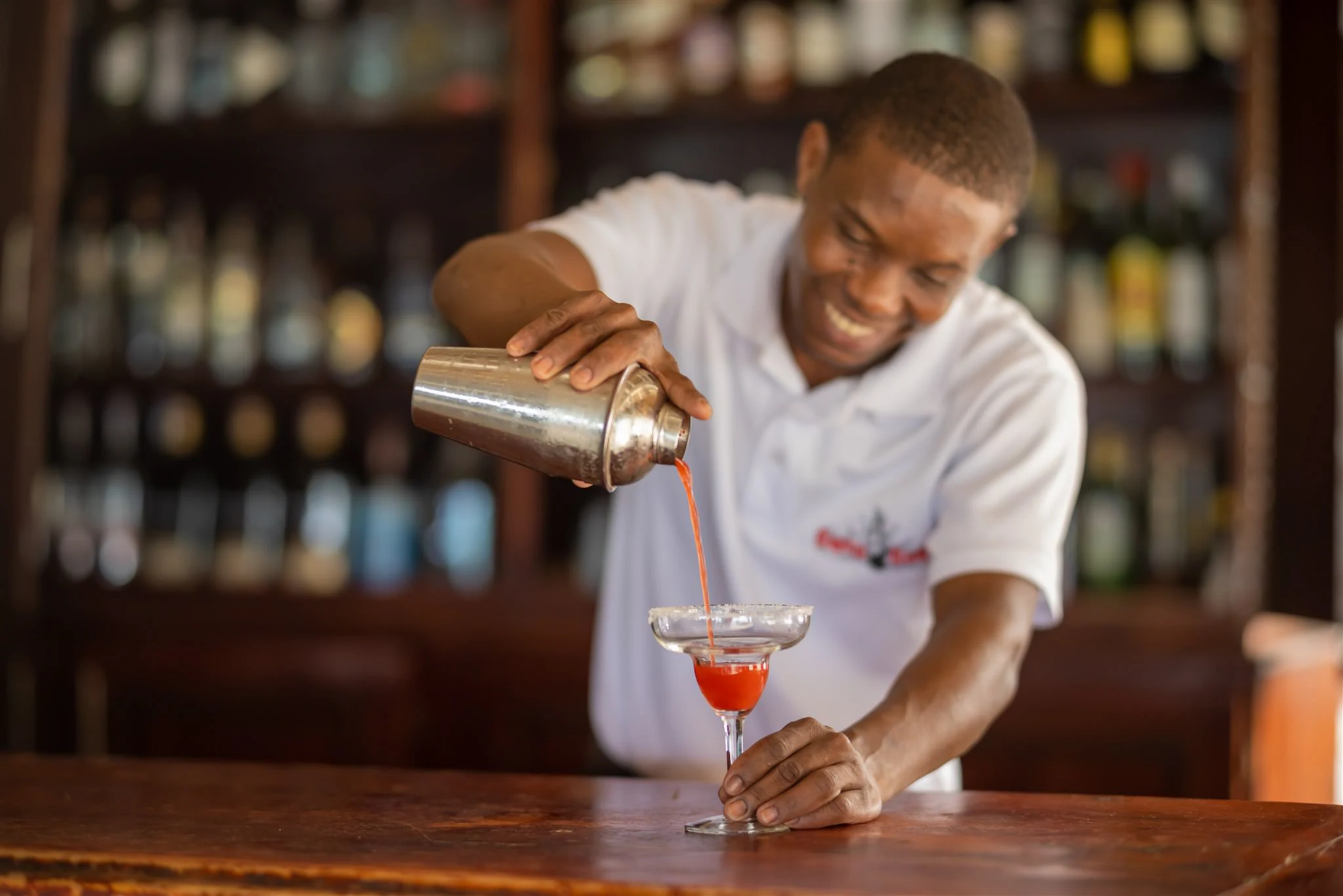 Bartender preparing a cocktail, pouring from a shaker