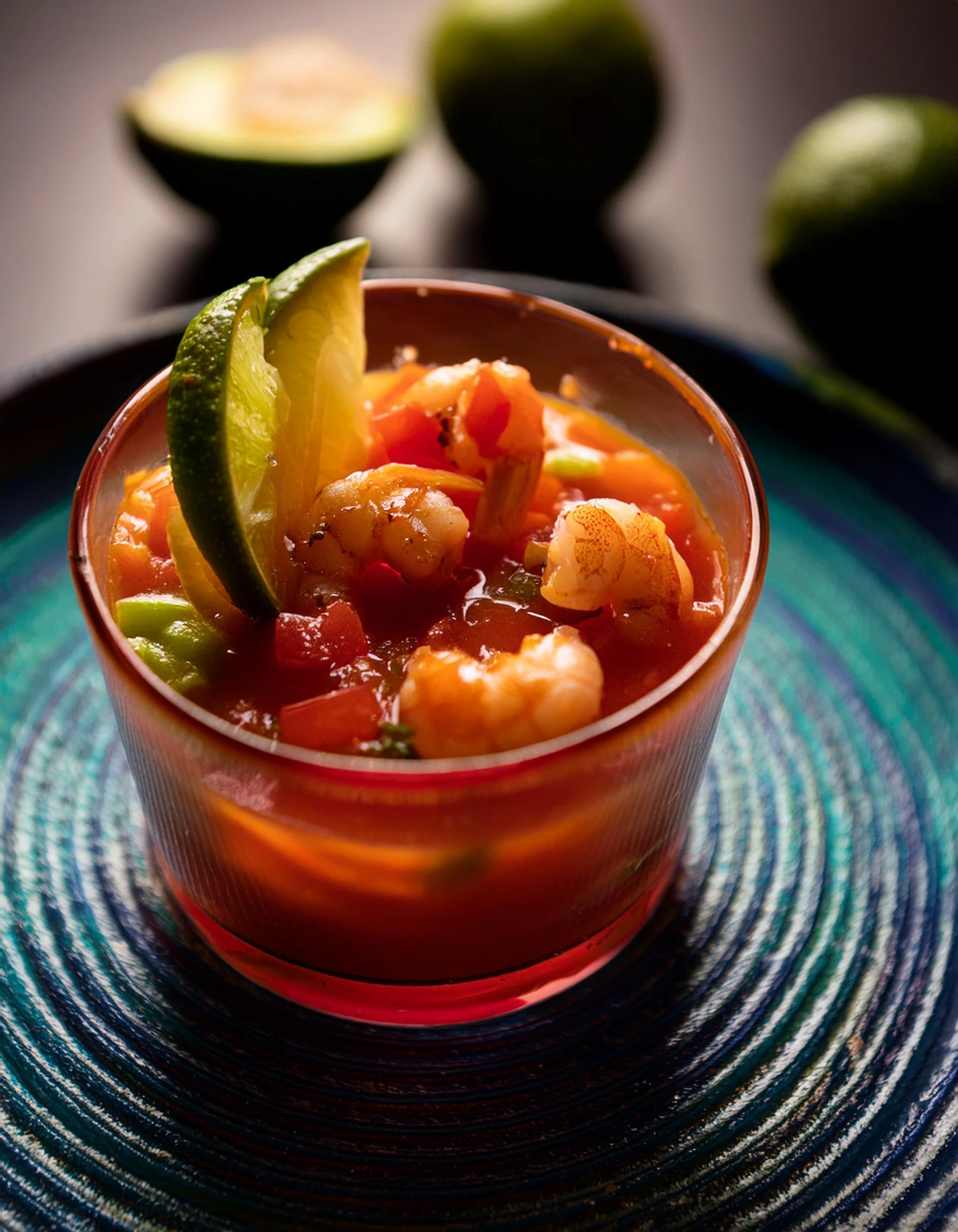 Shrimp cocktail in a glass with lime and sauce, on a handwoven placemat