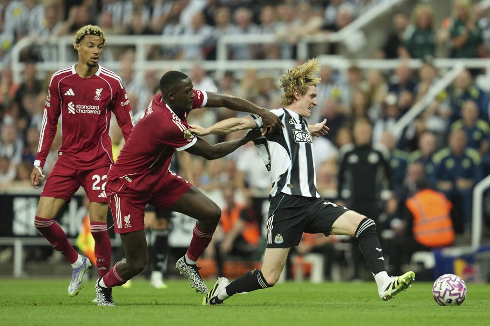 Ibrahima Konate melakukan tekel keras di kotak penalti, rambut terurai, ekspresi intens