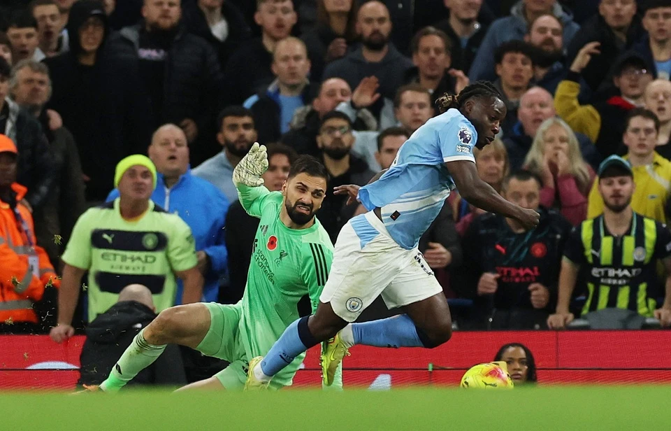 Jeremy Doku melepaskan tembakan kaki kiri ke gawang Liverpool, bola melengkung ke sudut atas, ekspresi ekstase
