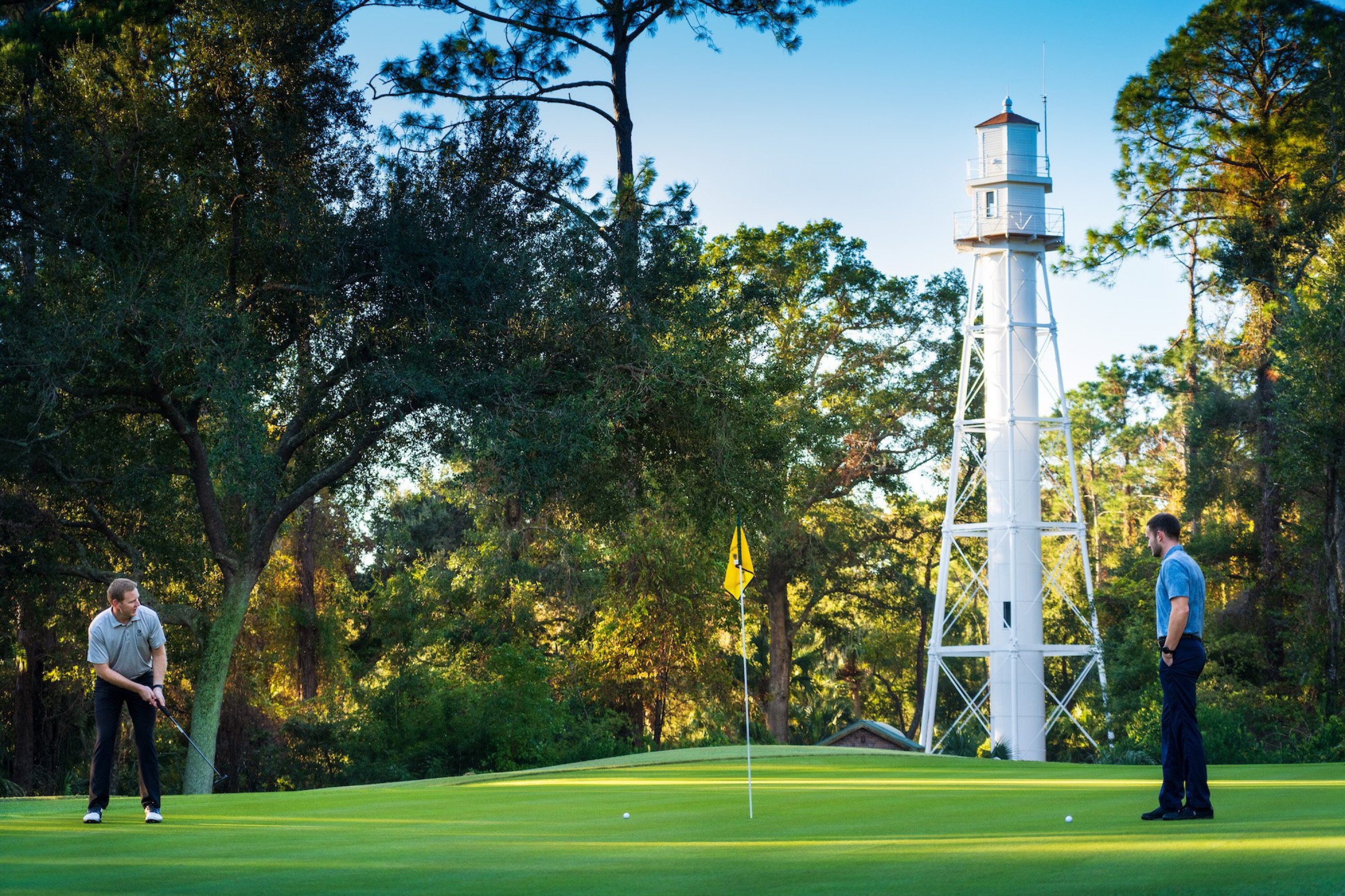 Golfer in front of Lighthouse at Arthur Hills Course