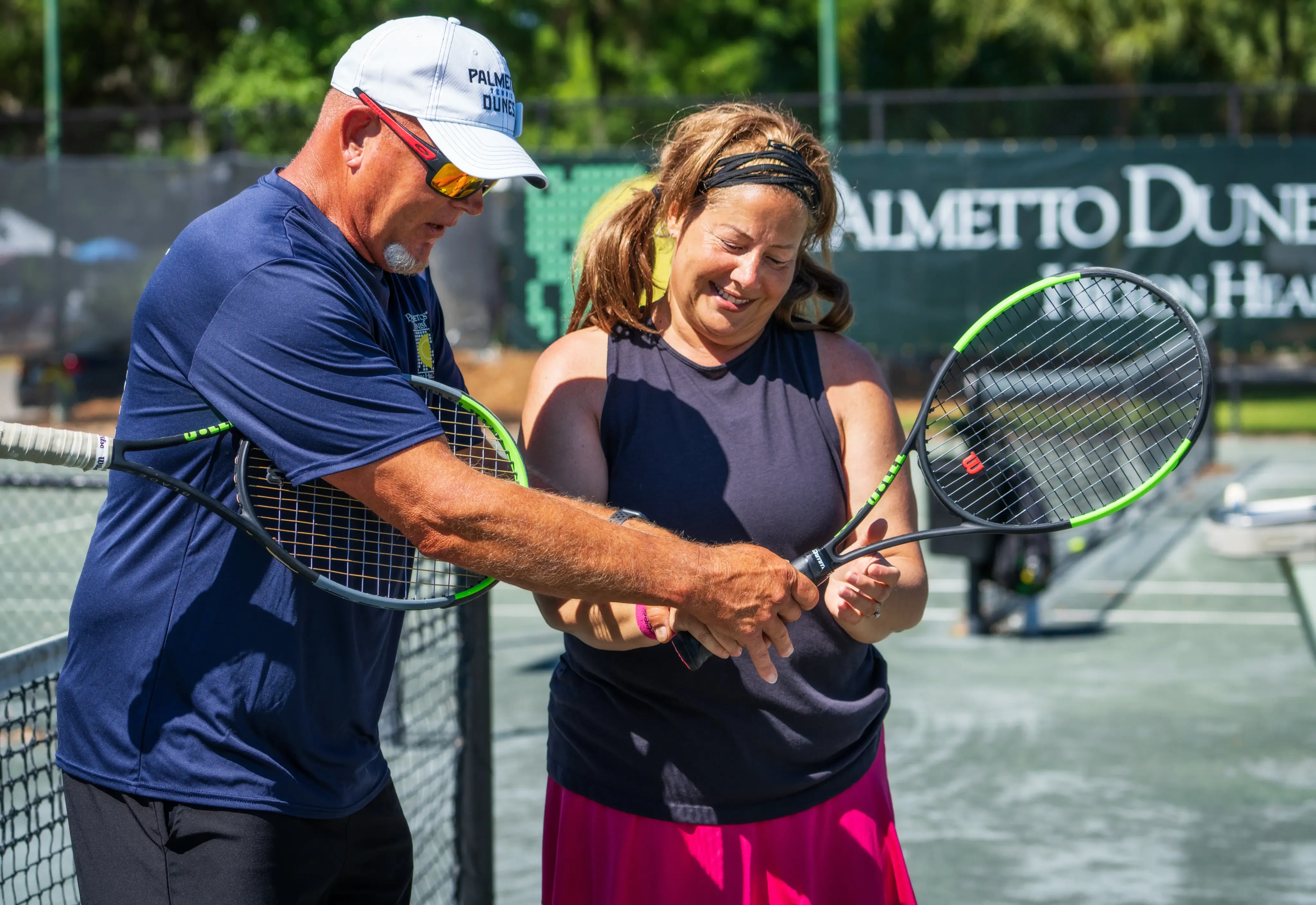 instructor shows a student the right hand placement on a tennis racket at Palmetto Dunes tennis center