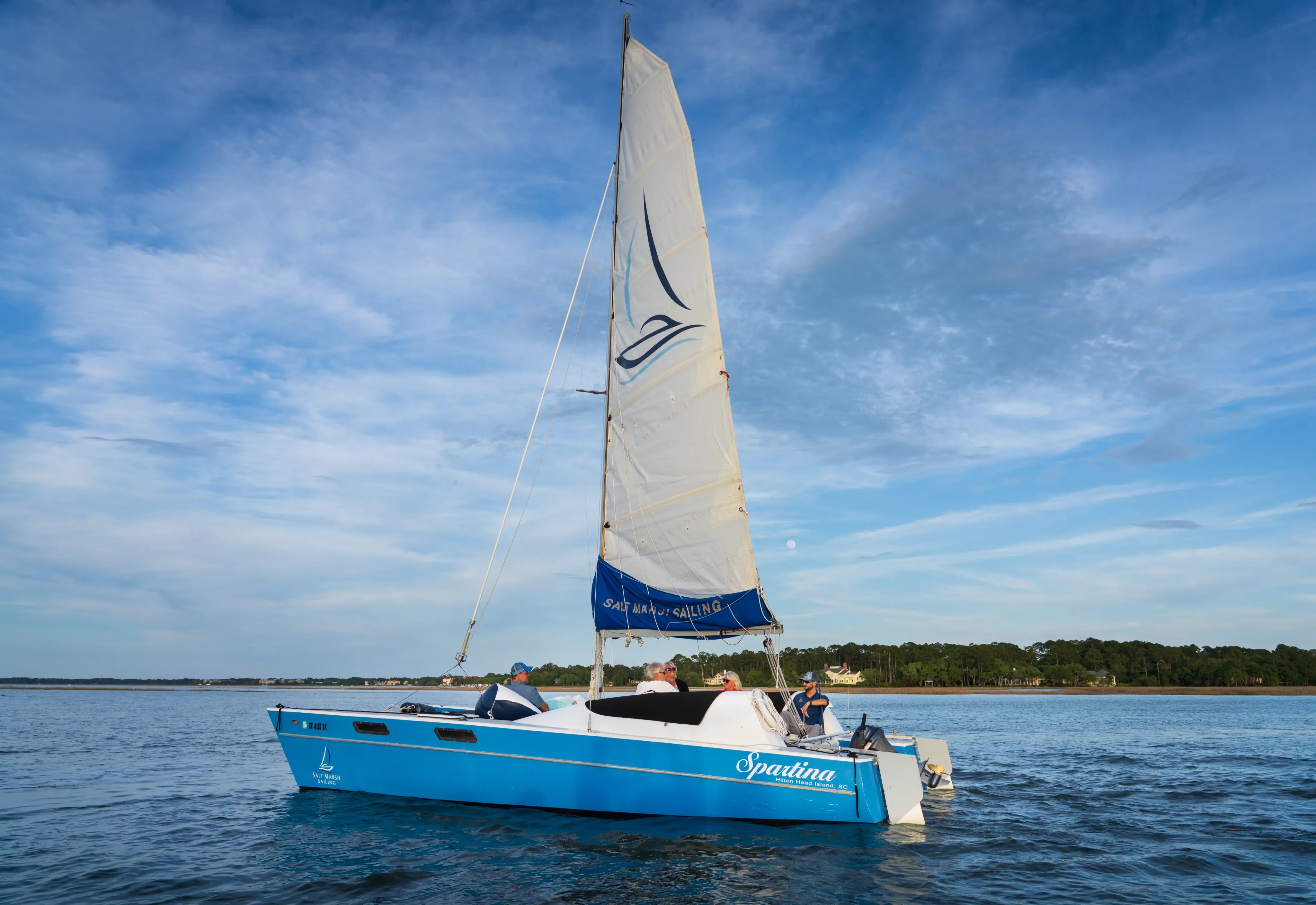 blue and white sailboat floating out on the water