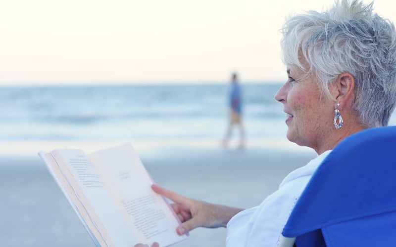 Lady reading book on beach