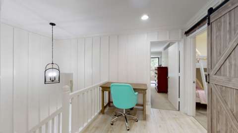 Hallway with a desk leading to bedrooms in a villa at Water Oak