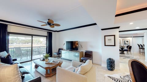 Living room with access to a balcony at Captain's Quarters