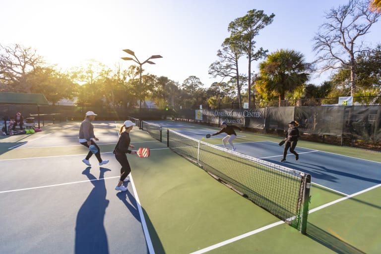 pickleball players playing at sunset
