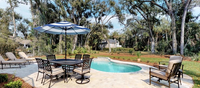 The backyard of a home in the Palmetto Dunes resort complex with a pool and patio furniture