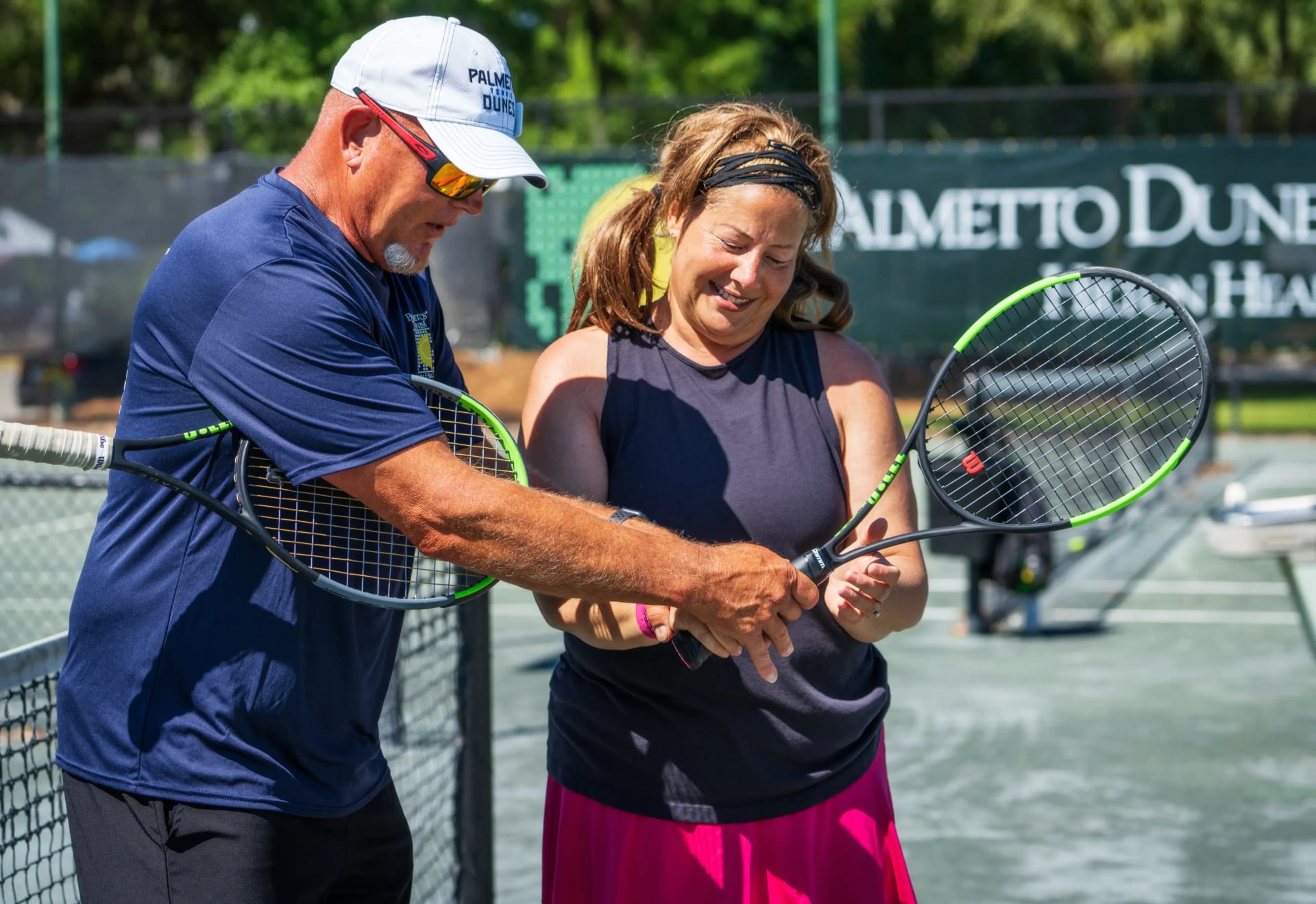 instructor shows a student the right hand placement on a tennis racket at Palmetto Dunes tennis center