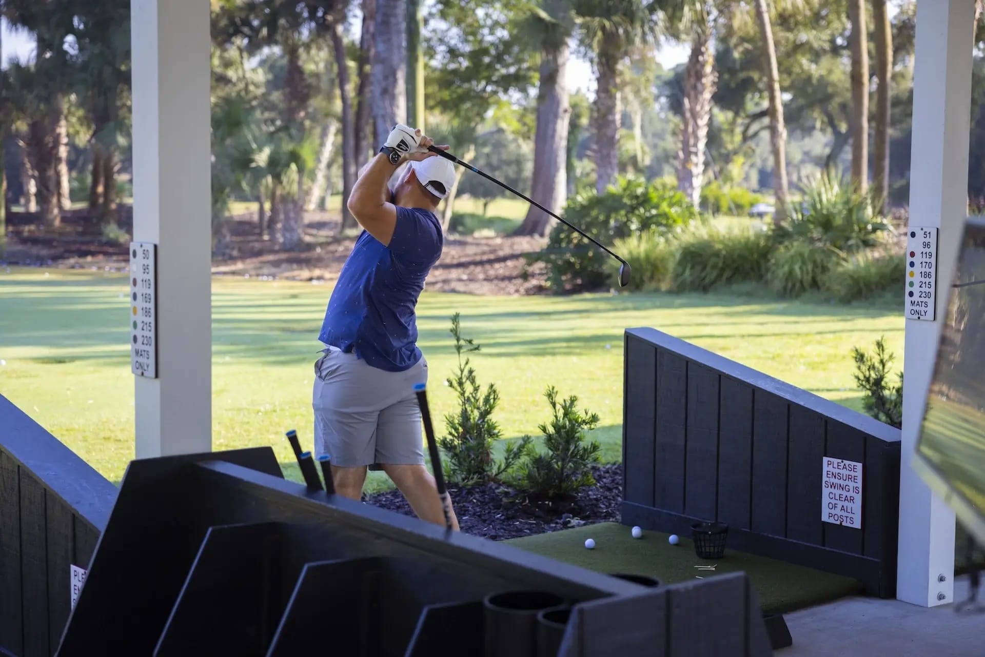 Man post swing at Toptracer Driving range