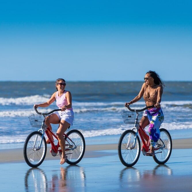 Friends riding bikes on the beach