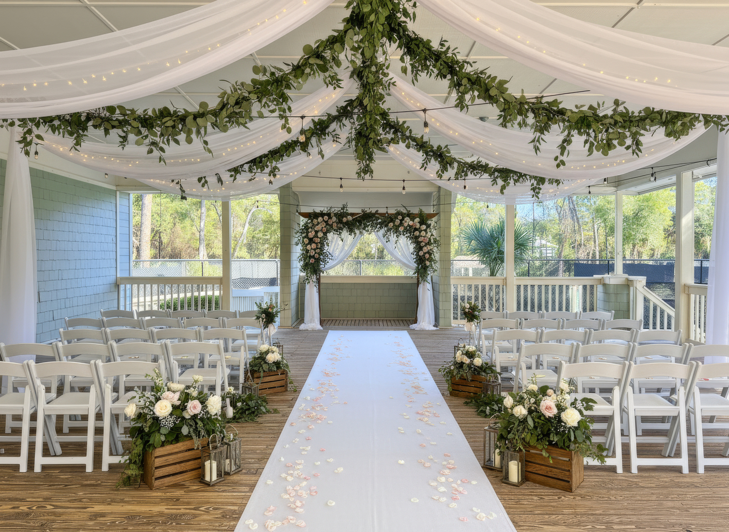 elegantly decorated wedding ceremony setup on the open air porch with white tapestry and hanging greenery