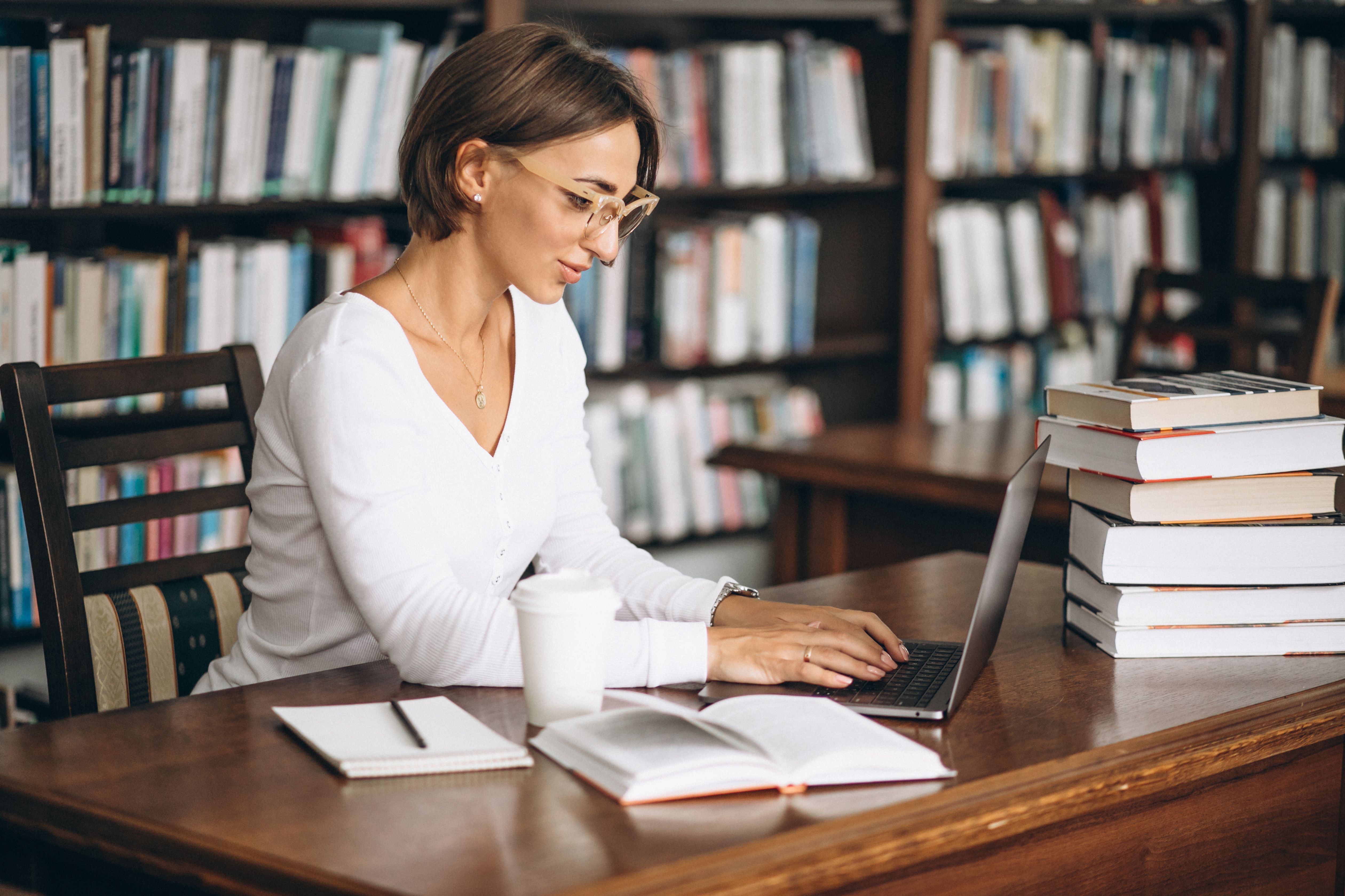 young-woman-sitting-library-using-books-computer.jpg