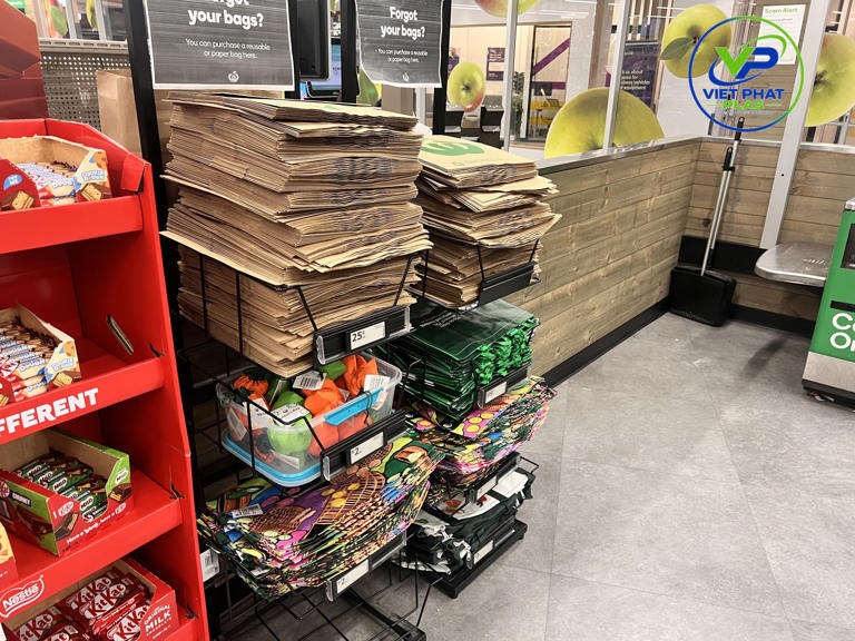 US grocery store checkout counter with recycled paper bags replacing plastic