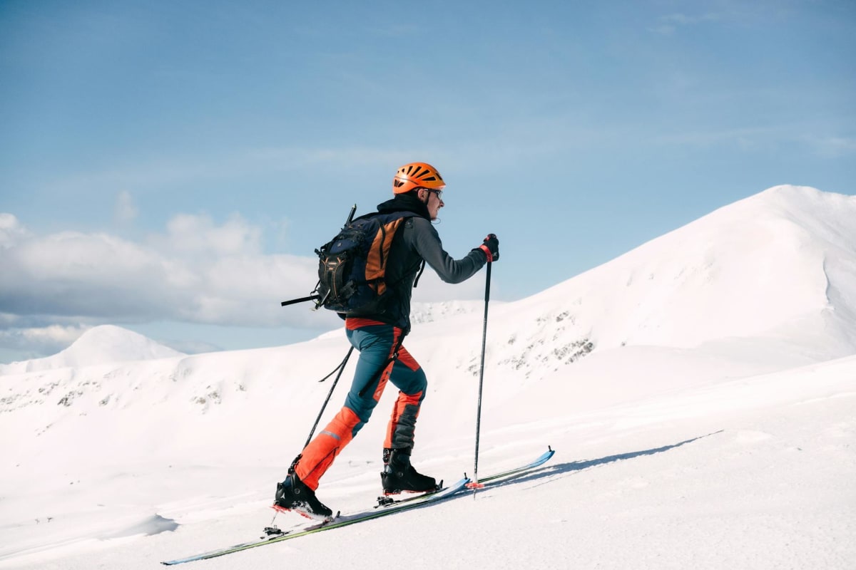 backcountry skier touring uphill deep powder mountains