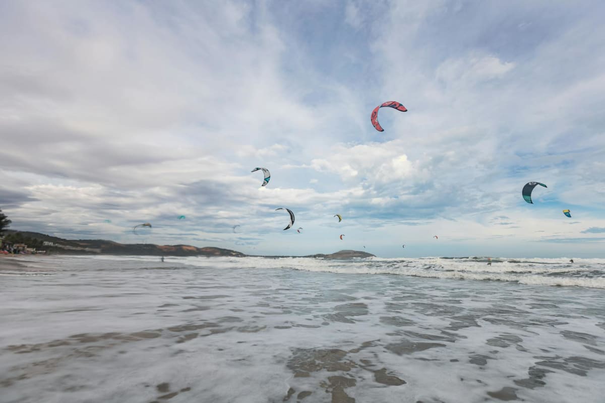 kiteboarding thermal wind coastal mountain backdrop Spain
