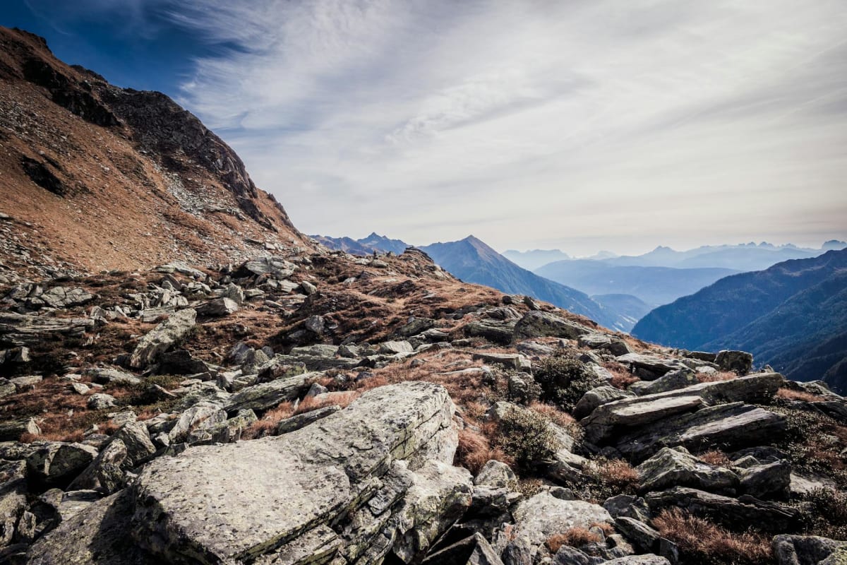 mountaineer descending steep scree field autumn