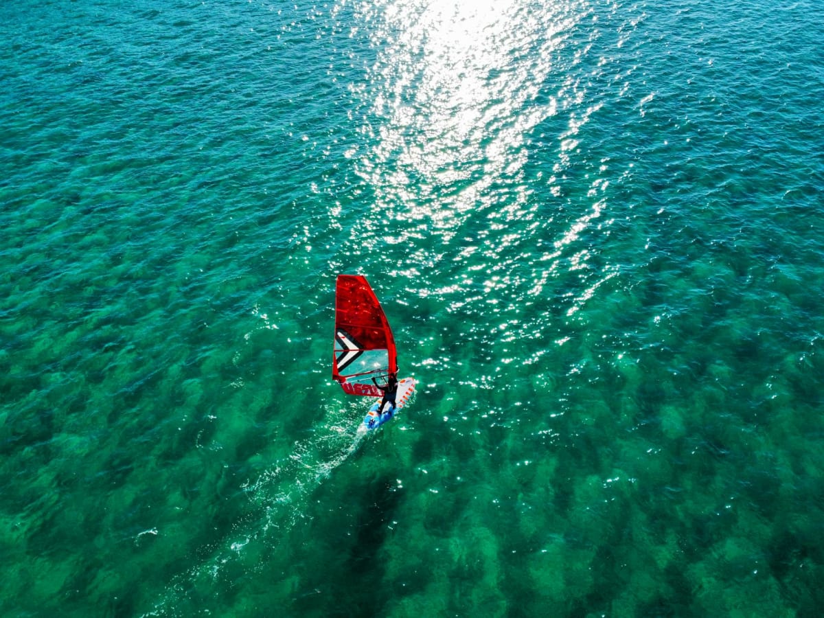 windsurfer aerial view turquoise water wave riding