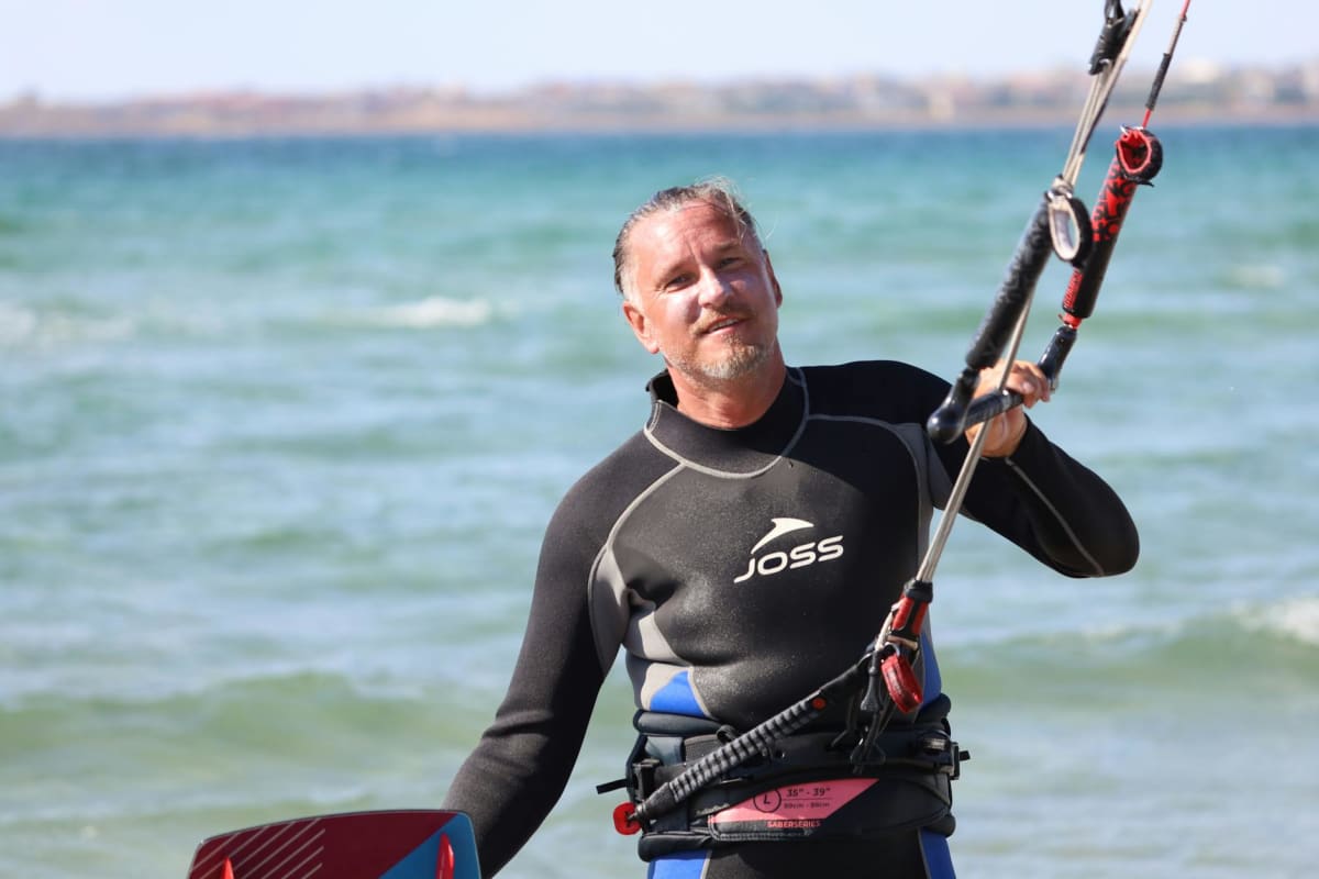 windsurfing gear laid out beach rash guard wetsuit