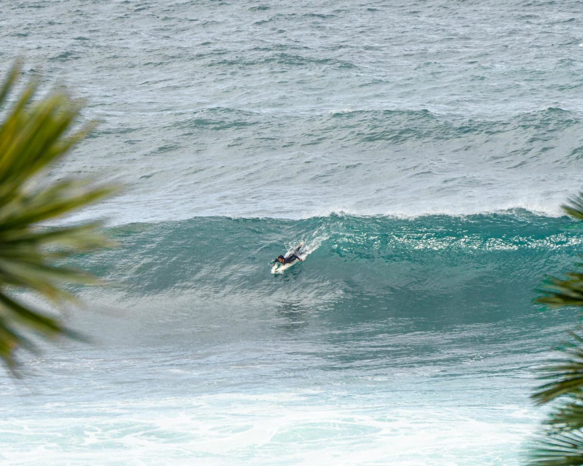 surfer paddling out tropical beach break morning