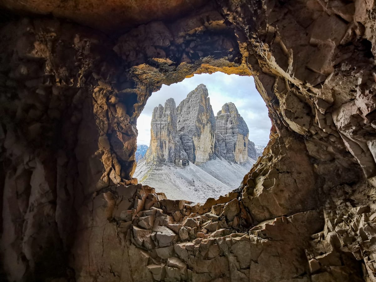 Climbers ascending dolomite multi-pitch route Tre Cime pale limestone vertical rock face