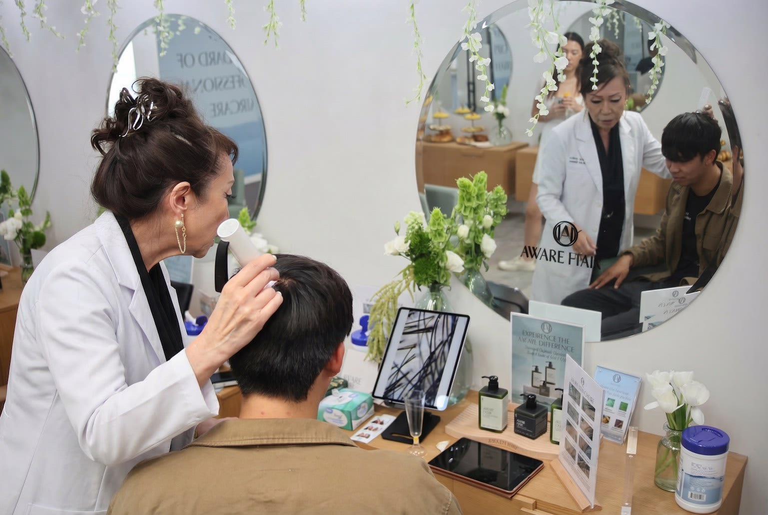 Tina Mui conducting a scalp assessment with a clinical microscope