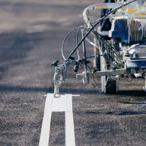 Worker applying markings to an airport runway