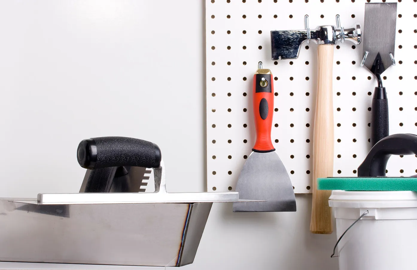 Plastering tools on a white corkboard