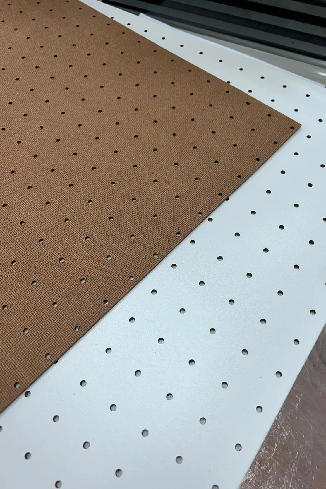Brown and white pegboard on a manufacturing table