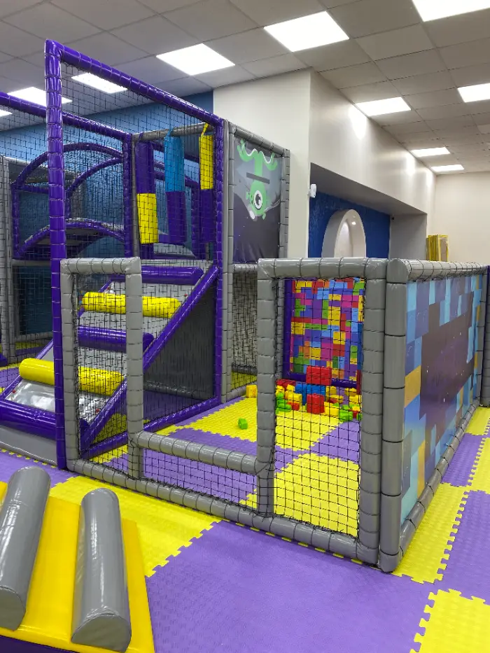 Grande aire de jeux douce avec des fonds violets et jaunes vibrants, le logo Softplay Turkey et un tableau des règles du terrain de jeu.