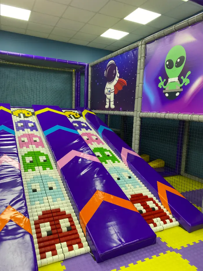 Grande aire de jeux douce avec des fonds violets et jaunes vibrants, le logo Softplay Turkey et un tableau des règles du terrain de jeu.