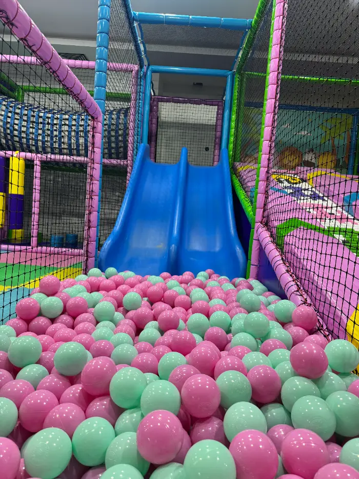 Rengarenk kaydıraklar, top havuzu ve tırmanma alanlarıyla dolu, çocukların güvenle eğleneceği modern bir soft play alanı.