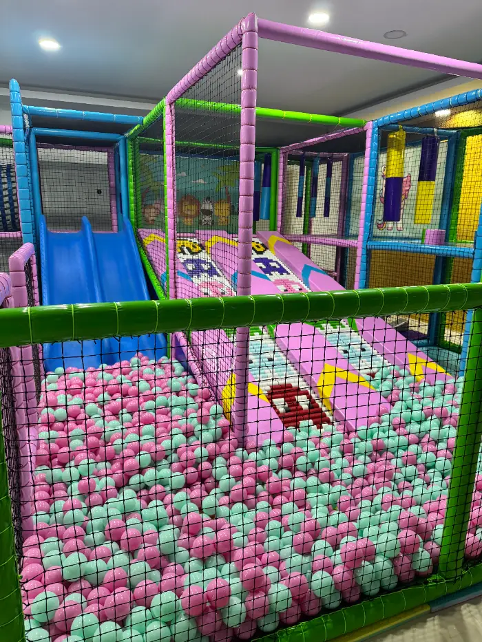 Rengarenk kaydıraklar, top havuzu ve tırmanma alanlarıyla dolu, çocukların güvenle eğleneceği modern bir soft play alanı.