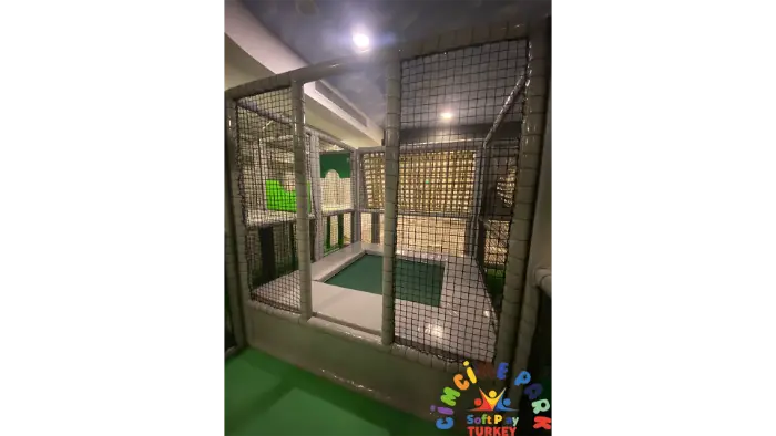 Rubi Platinium Otel'in çocuk eğlence merkezindeki güvenli filelerle çevrili, yeşil zeminli oyun alanı bölümü.