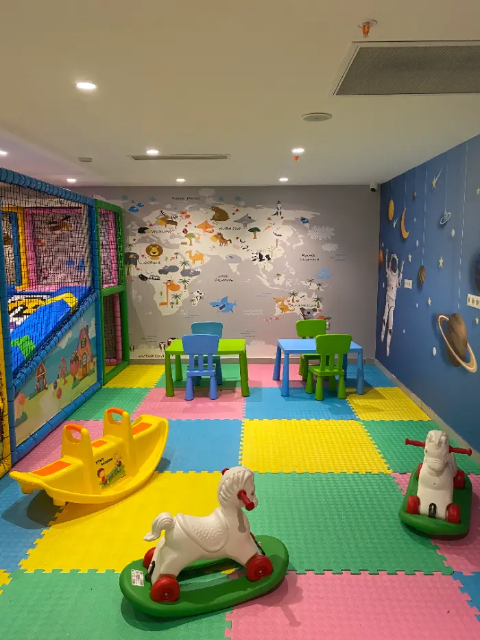 The general atmosphere of the entertainment center we prepared for children shows the classroom section together with the soft play area, world map and space-themed murals.