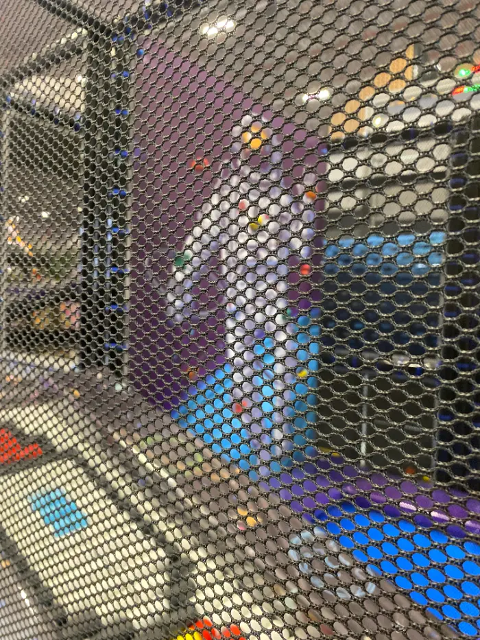 Güvenli siyah file arkasından görünen, çok katlı soft play yapısının içindeki renkli oyun elemanları ve tırmanma alanları.