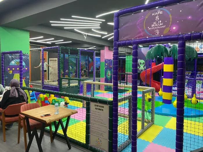 Antalya Cimcime Park'ta ürettiğimiz mor-yeşil uzay temalı, spiral kaydıraklı ve çok katlı soft play oyun alanı, renkli zemin matları ve aile kafeteryası ile çocuk eğlence merkezi.