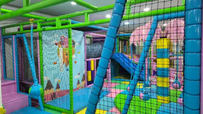 Une aire de jeux intérieure spacieuse et sûre conçue avec une variété de filets d'escalade et de jeux à bascule pour les enfants.