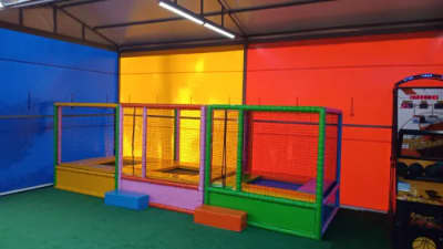 Situé sur un fond vert, des parcs de trampolines encadrés de différentes couleurs et un jeu d'arcade de basket-ball.