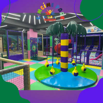 Aire de jeux centrale douce sur le thème des palmiers, toile de fond colorée et jouets suspendus