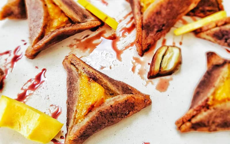 Close-up shot of pomegranate and delicata squash hamantaschen with sumac dough