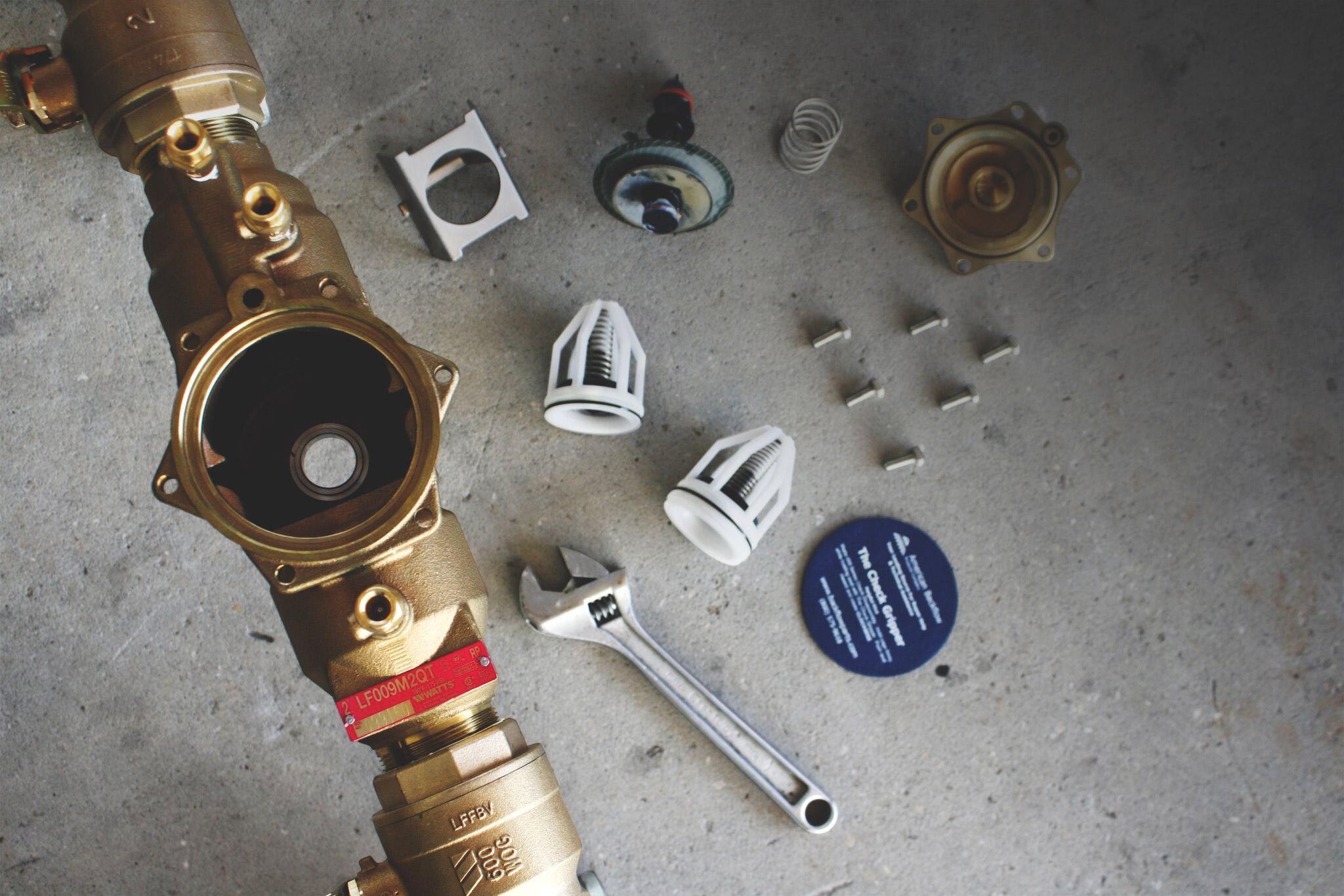 Certified technician repairing a backflow prevention device