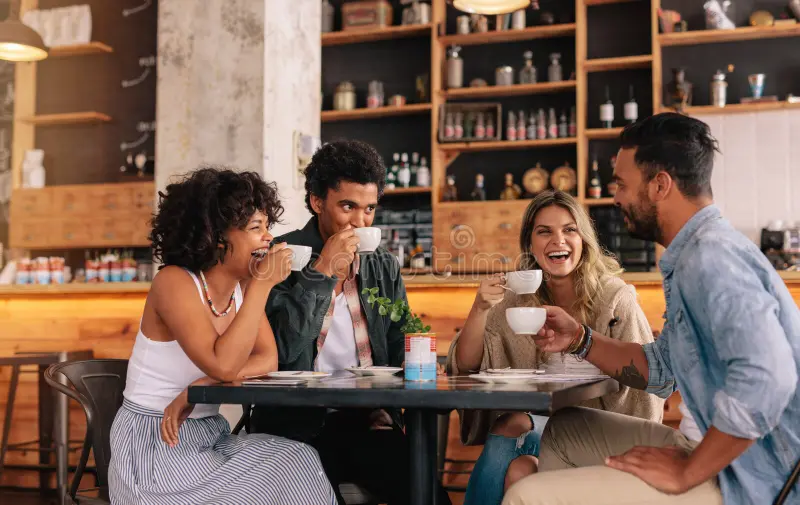 Diverse group of friends enjoying coffee together at cafe