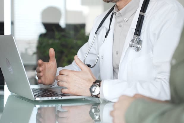 a doctor consulting his patient over an online call