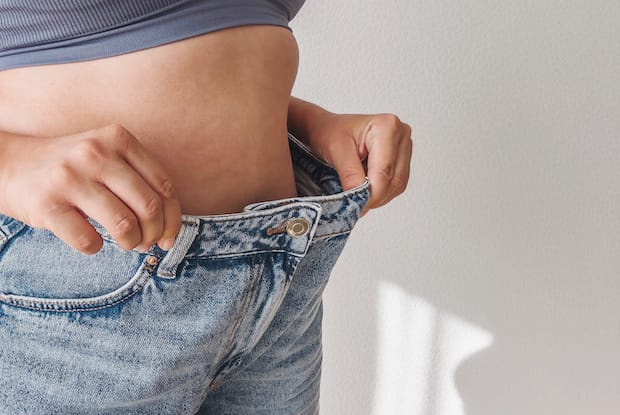 a woman showing weight loss results