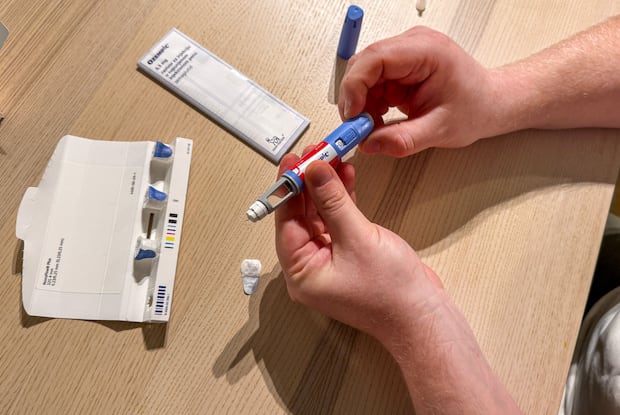 a person fiddling with a weight loss injection pen