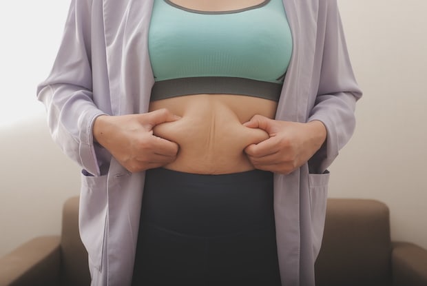 a woman experiencing bloating as a side effect of weight loss medication
